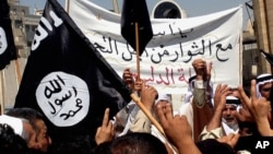 FILE - Demonstrators chant pro-al-Qaida-inspired Islamic State of Iraq and the Levant (ISIL) statements as they wave al-Qaida flags in front of the provincial government headquarters in Mosul, Iraq.