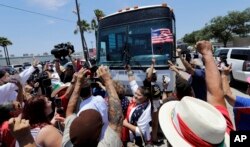 FILE - Demonstrators block a bus with immigrant children aboard during a protest outside the U.S. Border Patrol Central Processing Center, June 23, 2018, in McAllen, Texas. Extra law enforcement officials were called in to help control the scene and allow the bu