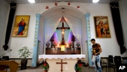 FILE - A parishioner walks past the altar as members of Lower Dafei Catholic Church hold an impromptu prayer vigil as they wait for Chinese officials to arrive and cut down their church's cross in Lower Dafei Village near Wenzhou in eastern China's Zhejia