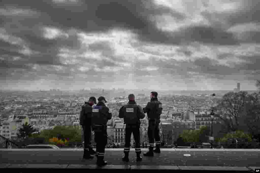 Paris is seen as French Police officers stand on guard near the church of Sacre Coeur, on top of the Montmartre hill, in Paris, Nov. 18, 2015. 