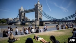 A woman takes a nap in the sunshine at Potters Fields Park near Tower Bridge in central London