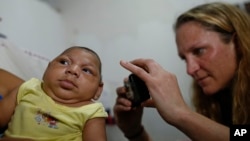 Pediatrician Alexia Harrist from the United States' Centers for Disease Control and Prevention (CDC) takes a picture of 3-month-old Shayde Henrique who was born with microcephaly, after examining him in Joao Pessoa, Brazil, Feb. 23, 2016. 