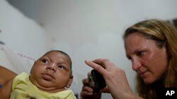 Dokter Alexia Harrist dari CDC memotret seorang anak berusia tiga bulan, Shayde Henrique, yang lahir dengan cacat lahir microcephaly di Joao Pessoa, Brazil (23/2).