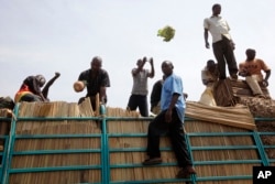 FILE - In this photo taken Jan. 13, 2011, South Sudanese men unload a vegetable truck that arrived from Uganda in a Juba market, Southern Sudan.