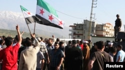 Residents block the road and wave Syrian opposition flags to protest what they call Lebanese shipments of diesel to the Syrian government a the Masnaa Border Crossing on April 28, 2013.