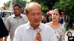 FILE - In this Sunday, June 3, 2012, file photo, Cambodian Prince Norodom Ranariddh greets people before casting his ballot in local elections at the Wat Than temple in Phnom Penh, Cambodia.