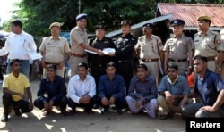 FILE - The seven Rohingya men to be deported sit as Indian and Myanmar security officials exchange documents before their deportation on India-Myanmar border at Moreh in the northeastern state of Manipur, India, Oct. 4, 2018.