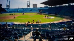 People work near a statue of Cuban baseball fan and entertainer Armando Luis Torres Torres at the Latinoamericano stadium, March 16, 2016. A friendly game will be played on March 22 between the Cuban national baseball team and the Tampa Bay Rays, in Havan