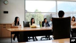 FILE - University of Connecticut sophomore Anyi Yang of Beijing, left, attends a meeting of the Chinese students and scholars association on campus in Storrs, Conn., Sept. 18, 2015. 