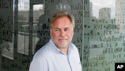 FILE - Eugene Kaspersky, Russian antivirus programs developer and chief executive of Russia's Kaspersky Lab, stands in front of a window decorated with programming code's symbols at his company's headquarters in Moscow, July 1, 2017.