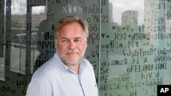 Eugene Kaspersky, Russian antivirus programs developer and chief executive of Russia's Kaspersky Lab, stands in front of a window decorated with programming code's symbols at his company's headquarters in Moscow, July 1, 2017.