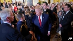 President Donald Trump stops to greet Sen. Ron Johnson, R-Wis., left, after speaking on combatting drug demand and the opioid crisis in the East Room of the White House in Washington, Thursday, Oct. 26, 2017.