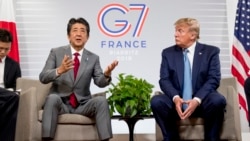 Japanese Prime Minister Shinzo Abe, left, accompanied by U.S President Donald Trump, speaks at a news conference at the G-7 summit in Biarritz, France, Sunday, Aug. 25, 2019, where they announced that the U.S. and Japan have agreed in principle on a new t