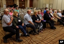 FILE - Landowners who object to the Keystone XL pipeline being built through their property sit in the front row as they listen to testimony before the Nebraska Public Service Commission in Lincoln, Nebraska, Aug. 7, 2017.