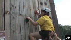 Helen O'Brien, who is autistic and developmentally delayed, tackles the climbing wall at Camp Accomplish in Nanjemoy, Maryland.