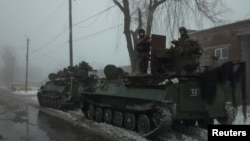 Members of the Ukrainian armed forces ride armored personnel carriers near the government-held industrial town of Avdiivka, Ukraine, Feb. 4, 2017. 