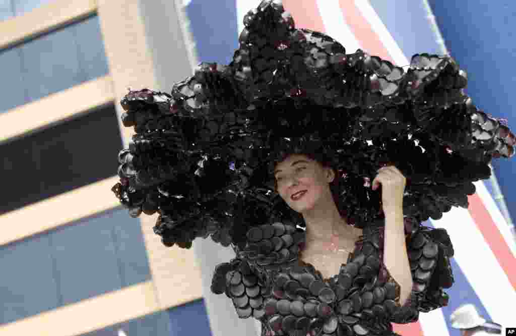 Larisa Katz poses for the media with a hat made from chocolate packaging on the second day of the Royal Ascot horse race meeting in Ascot, England.