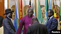 FILE - South Sudan's rebel leader Riek Machar (R) and South Sudan's President Salva Kiir (L) hold a priest's hands as they pray before signing a peace agreement in Addis Ababa, May 9, 2014.