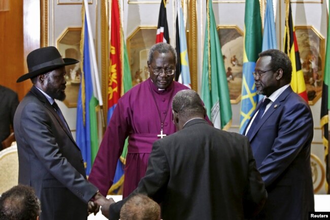 FILE - South Sudan's rebel leader Riek Machar, right, and South Sudan's President Salva Kiir, left, hold a priest's hands as they pray before signing a peace agreement in Addis Ababa, May 9, 2014.