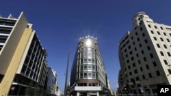 A woman walks in front of the building that houses the Arab Bank, center, in downtown Beirut, January 20, 2011