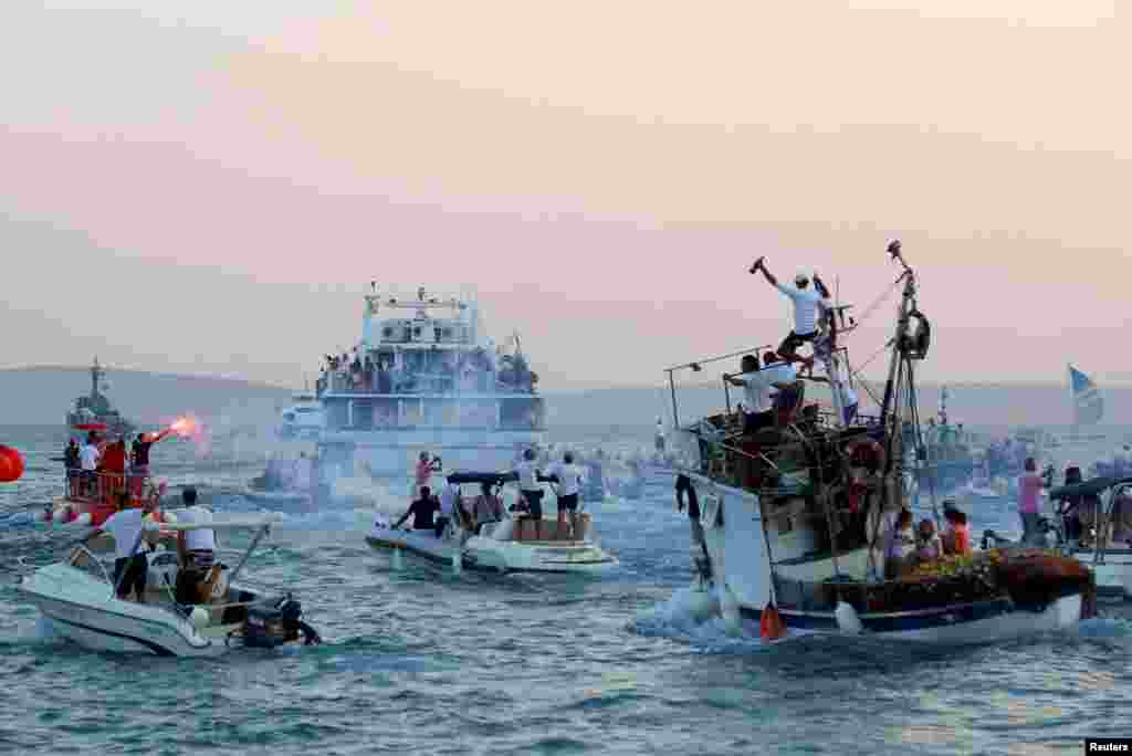 People on boats follow a catamaran that carries a coffin with the body of singer Oliver Dragojevic, during his funeral in Split, Croatia, July 31, 2018.