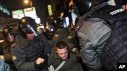 Police officers detain a protester during a rally at Triumphal Square in downtown Moscow, Wednesday, Dec. 7, 2011.