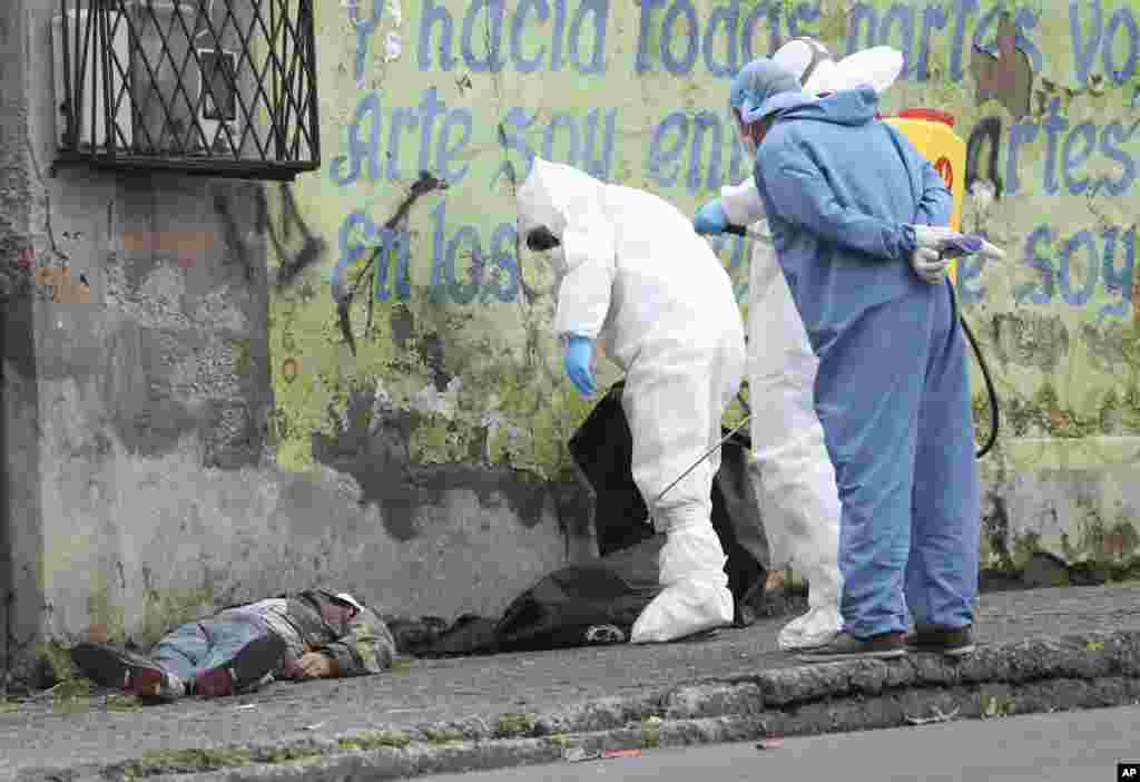 Forensic investigators look at the body of a man infected with the new coronavirus who collapsed on the street and died, according to Police Captain Diego Lopez, in Quito, Ecuador, May 5, 2020.