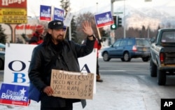 An unnamed homeless person waives soliciting money amongst political campaign sign wavers in Anchorage, Alaska in 2008. Nearly 45 percent of homeless in that state are Alaska Native, some, like this man, U.S. military veterans.