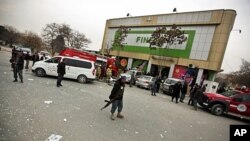 Afghan policeman keeps watch after a suicide bomb attack at Finest supermarket in Kabul, January 28, 2011