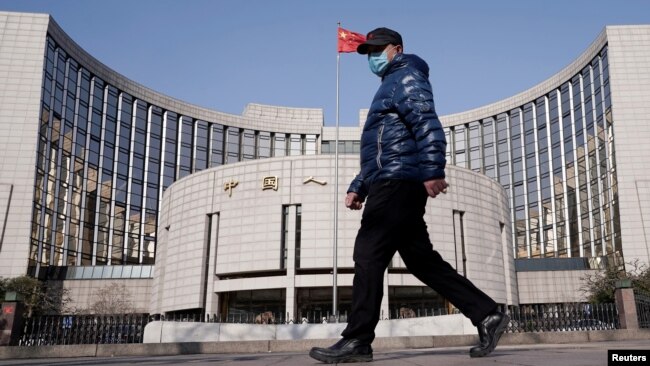 一名戴着口罩的男子走过北京的中国人民银行总部。(2020年2月3日)