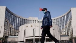 一名戴著口罩的男子走過北京的中國人民銀行總部。（2020年2月3日）