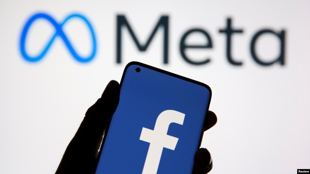 A smartphone with Facebook's logo is seen in front of displayed Facebook's new rebrand logo Meta in this illustration taken Oct. 28, 2021. 