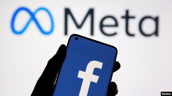 A smartphone with Facebook's logo is seen in front of displayed Facebook's new rebrand logo Meta in this illustration taken Oct. 28, 2021. 