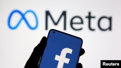 A smartphone with Facebook's logo is seen in front of displayed Facebook's new rebrand logo Meta in this illustration taken Oct. 28, 2021.