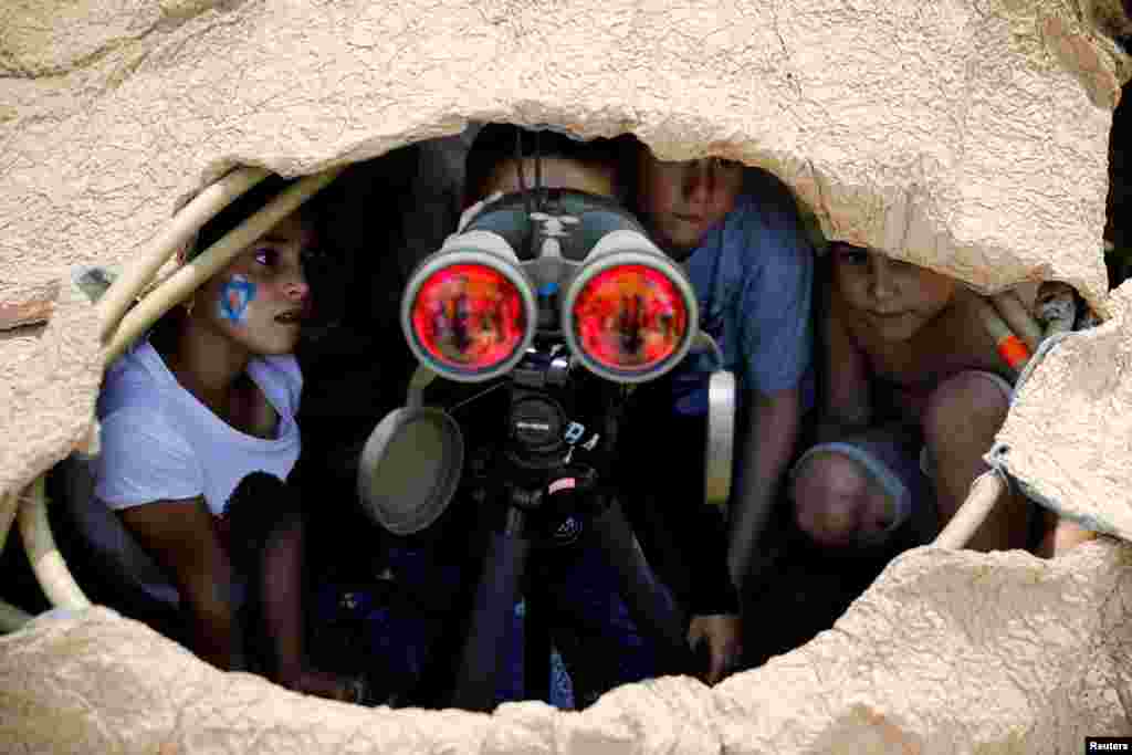 Children look through binoculars during a display of Israeli Defense Forces equipment and abilities, as part of the celebrations for the 69th anniversary of Independence Day in the southern city of Sderot, May 2, 2017.