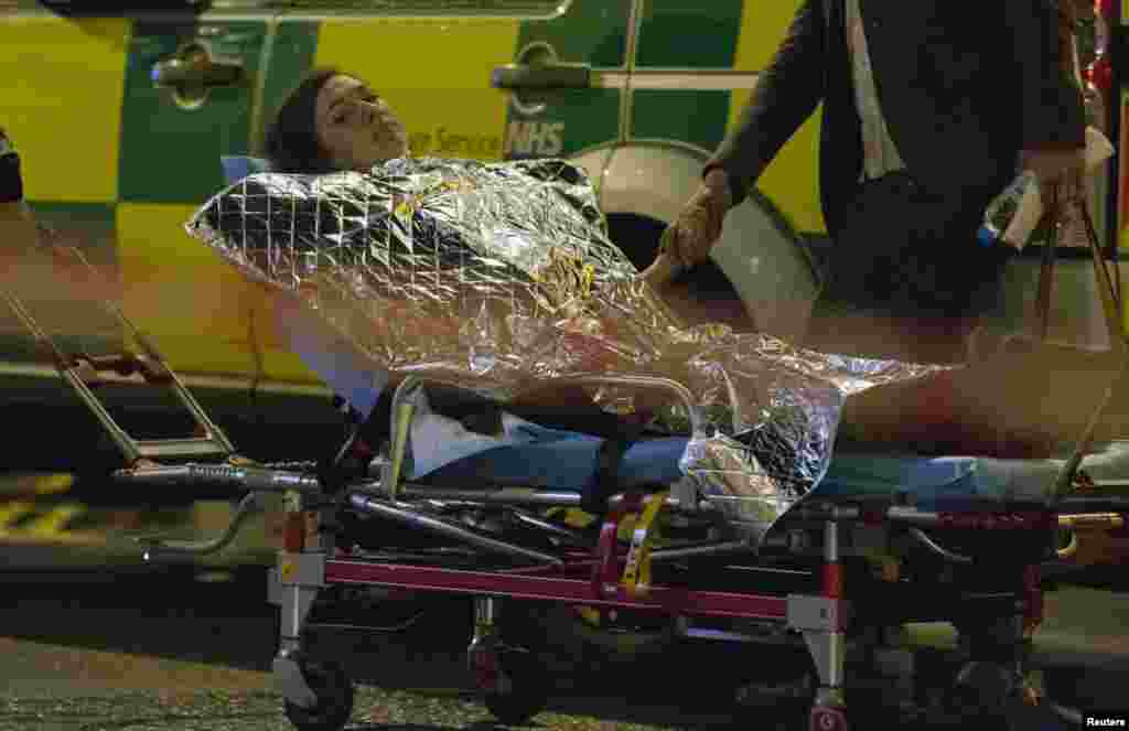 A woman receives medical attention after part of the ceiling collapsed at the Apollo Theatre, Shaftesbury Avenue, London, Dec. 19, 2013. 