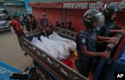 Bangladesh policemen drive off in a mini truck with bodies of suspected militants after a raid in Narayanganj district near Dhaka, Bangladesh, Aug. 27, 2016.