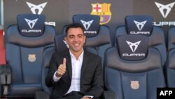 Newly-appointed FC Barcelona's Spanish coach Xavi Hernandez poses for pictures during his presentation ceremony at the Camp Nou stadium in Barcelona on November 8, 2021. (Photo by LLUIS GENE / AFP)