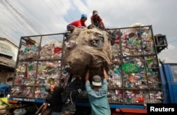 FILE - Workers load collected plastic bottles on to a truck at a junk shop in Manila, March 10, 2015. The Philippines placed third among the list of countries with the most ocean plastic pollution per year.