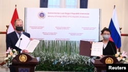 Menteri Luar Negeri Rusia Sergei Lavrov dan Menteri Luar Negeri Indonesia Retno Marsudi menunjukkan dokumen dalam konferensi pers setelah pertemuan di Jakarta, 6 Juli 2021. (Courtesy: Kemenlu RI/Handout via REUTERS)
