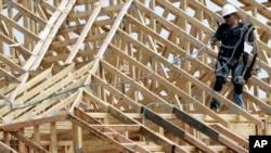 Một công nhân xây dựng làm việc trên mái nhà của khu chung cư được xây dựng tại Spring, Texas, ngày 27/3/2015.
