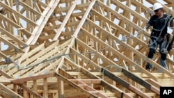 Một công nhân xây dựng làm việc trên mái nhà của một khu chung cư được xây dựng tại Spring, Texas.