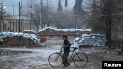 Jeune cycliste dans une rue de la ville d'al-Rai, dans le Nord de la province syrienne d'Alep, le 27 décembre 2016 