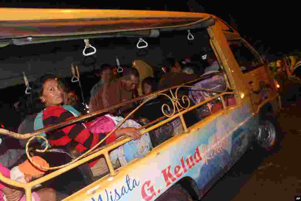 Warga mengungsi dari rumahnya di lereng Gunung Kelud, Kediri, Jawa Timur (13/2), dengan mobil wisata.