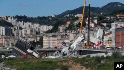Les secouristes, toujours à pied d'oeuvre, dans les décombres du pont routier de Morandi qui s'est effondré à Gênes, dans le nord de l'Italie, le mercredi 15 août 2018.(AP Photo / Antonio Calanni)