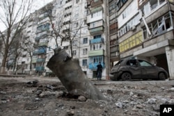 A piece of an exploded Grad missile is photographed outside an apartment building in Vostochniy, district of Mariupol, Eastern Ukraine, Jan. 25, 2015.