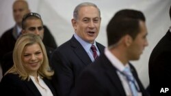 FILE - Israeli Prime Minister Benjamin Netanyahu and his wife Sara are seen arriving for Likud party primary elections in Jerusalem in a Dec. 31, 2014, photo. The couple have been no strangers to negative publicity regarding what many see as their extravagant lifestyle.