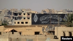 FILE - A banner belonging to Islamic States fighters is seen during a battle with member of the Syrian Democratic Forces in Raqqa, Syria, Aug. 16, 2017. 