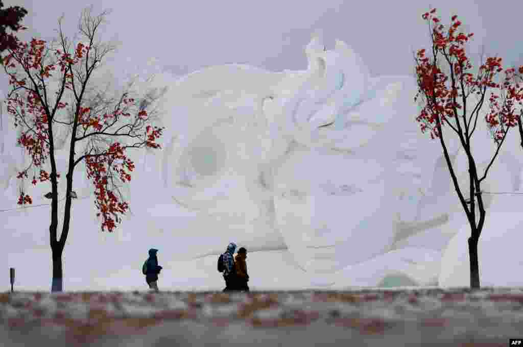 People walk past a snow sculpture in Harbin in China's northeastern Heilongjiang province.