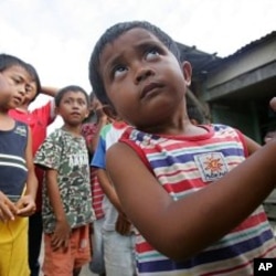 Arfaisal Marsaleh, 2, a stateless child, holds on to his mother as he plays with his friends in a slum village in Kinarut, in Malaysia's Sabah state on the Borneo island. (file photo)